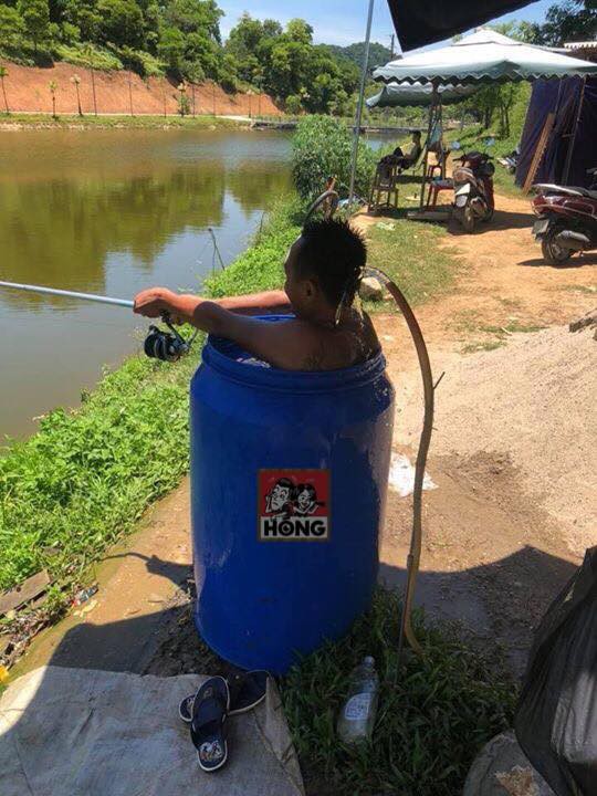 Thời tiết nắng nóng 40 độ, người đàn ông nhảy vào thùng phuy đựng nước ngồi câu cá